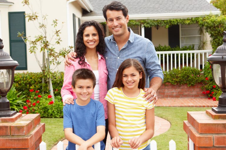 Family in front of house thinking about homeowners insurance
