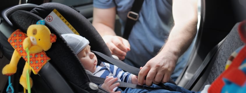 Baby Boy in Car Seat and Parent Buckling him up