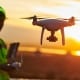 Construction worker operating a drone over a work site