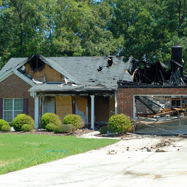 brick fronted house with major fire damage indicating the need to put in a homeowners insurance claim