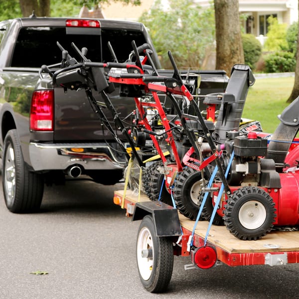pickup truck with trailer full of snowblowers