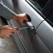 Man trying to break into a car using a screwdriver