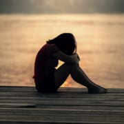 grieving woman alone on dock by water