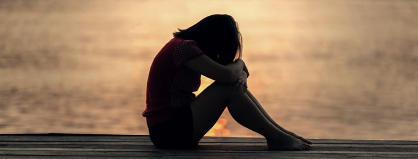 grieving woman alone on dock by water