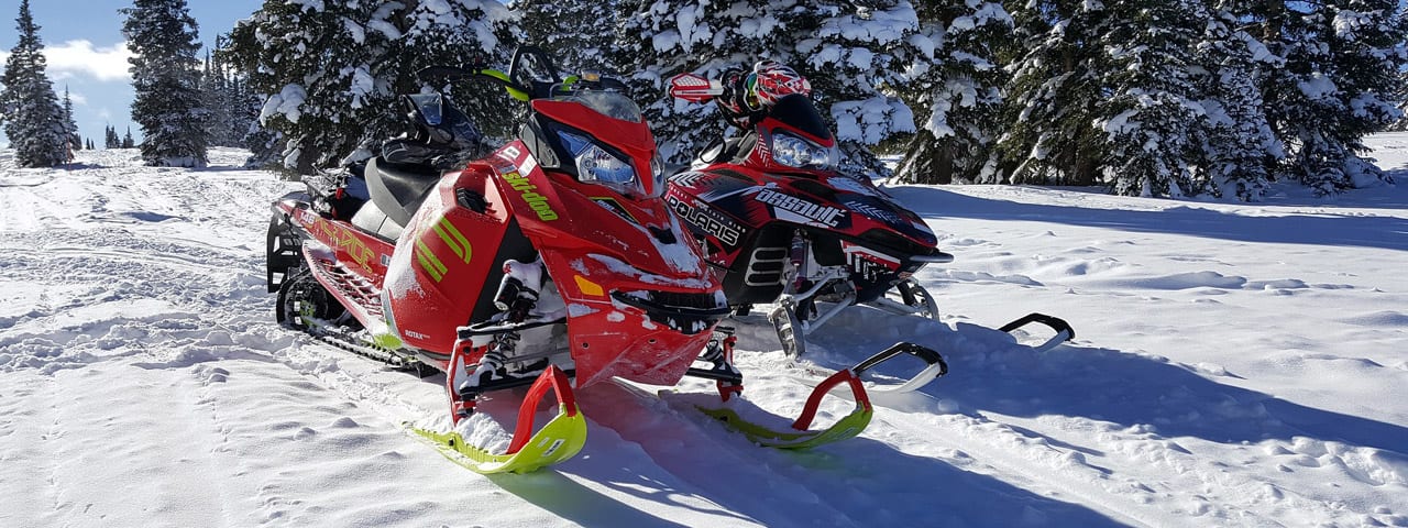 pair of snowmobiles parked in snow