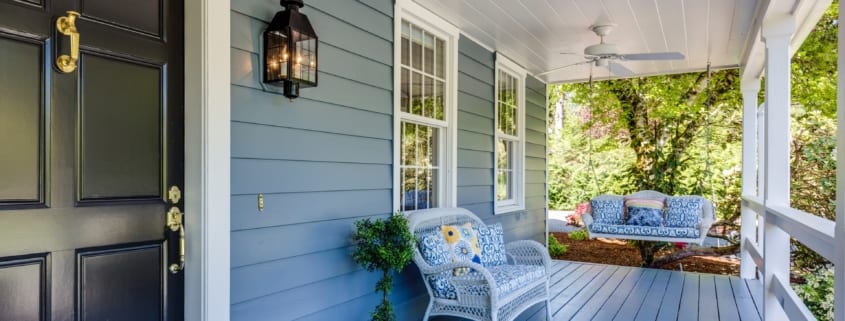 Outside a country house looking at a porch with seating